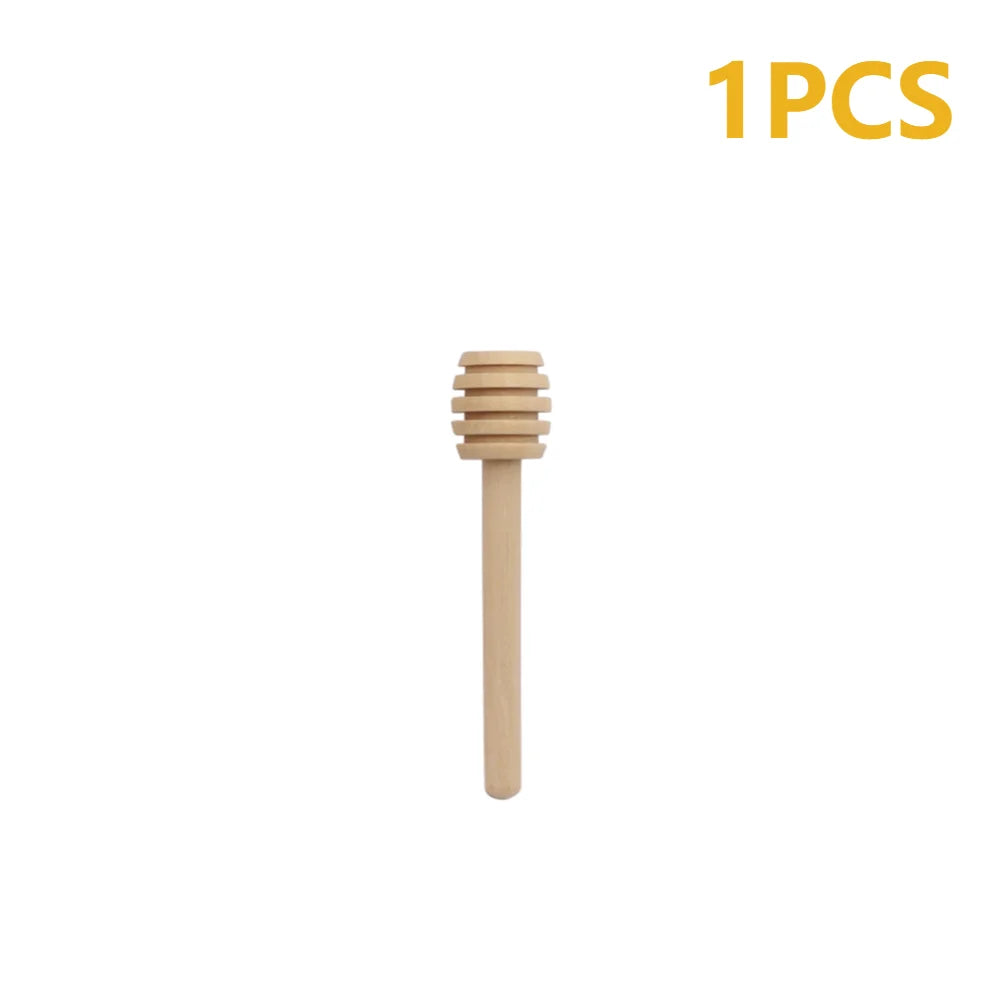 A single natural wood honey dipper stick with a wooden comb-like top.