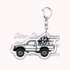 A silver metal key ring attached to a durable keychain featuring an off-road truck silhouette.