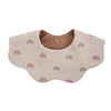 A light beige muslin cotton baby bib and burp cloth with a brown interior and small rainbow patterns.