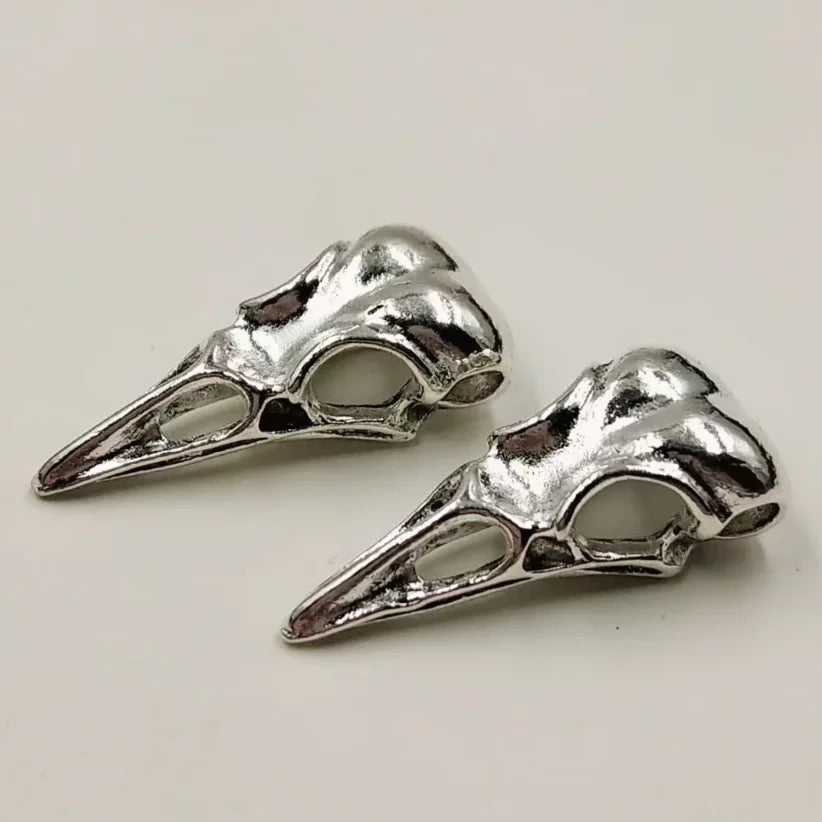 A pair of silver gothic skull and crow head charms for jewelry making