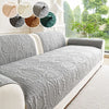A gray anti-slip sofa cover is displayed on a light-colored sofa, with swatches of various fabric textures above it.
