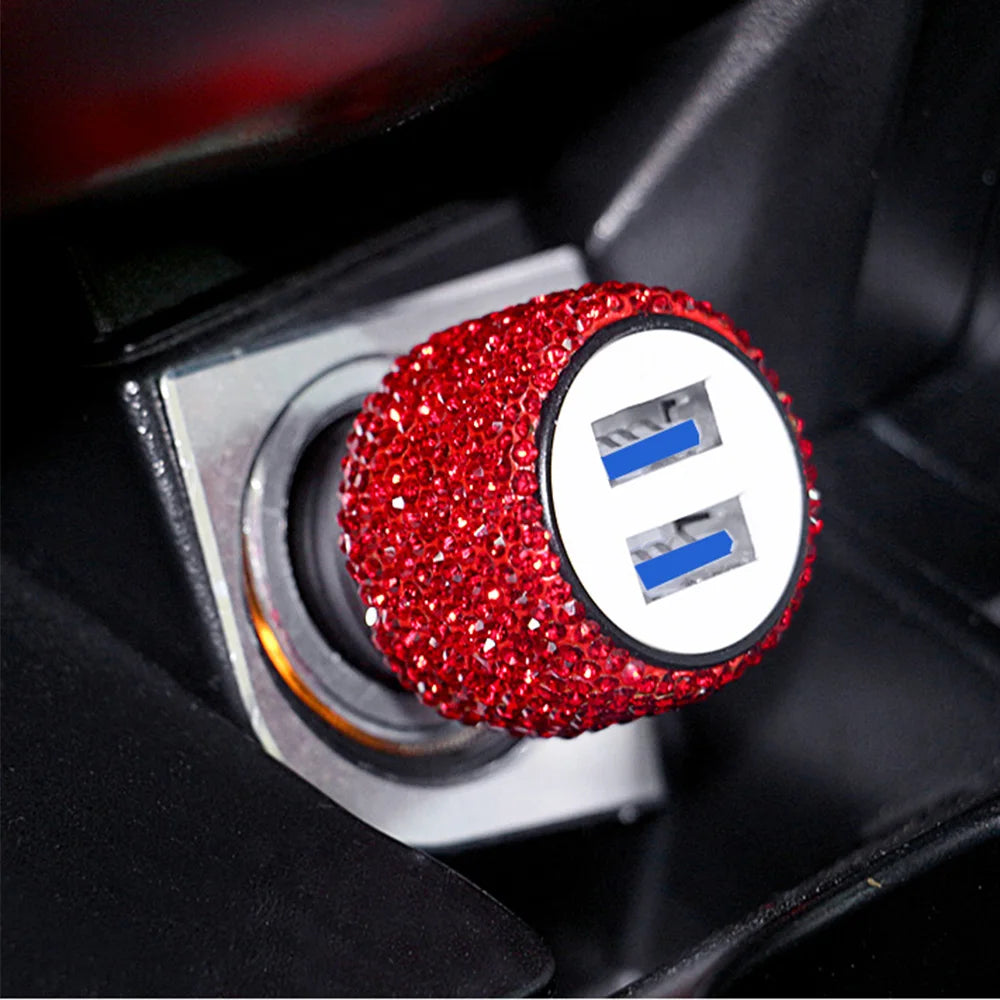 A red rhinestone dual USB car charger with blue accents is shown in a close-up view.