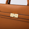 A close-up of a tan leather handbag with gold hardware and a matching coin purse.
