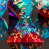 A close-up of a red resin polyhedral die with gold markings, reflecting light and showing a triangular shape.