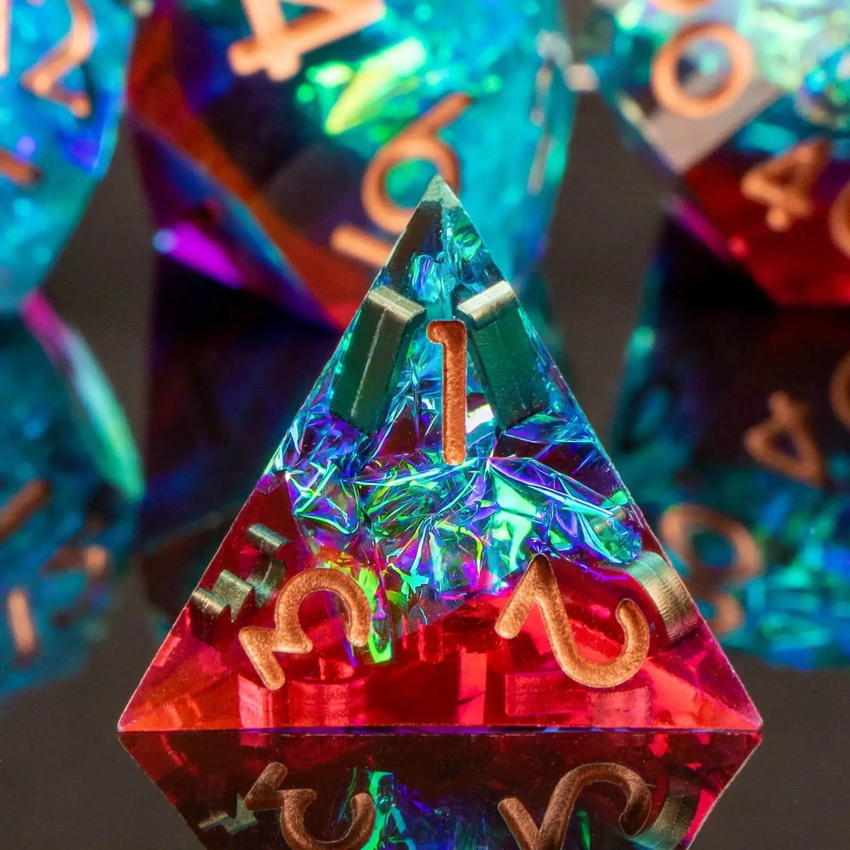 A close-up of a red resin polyhedral die with gold markings, reflecting light and showing a triangular shape.