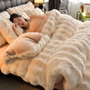 A woman relaxing on a fluffy beige faux fur bedding set in a bedroom.