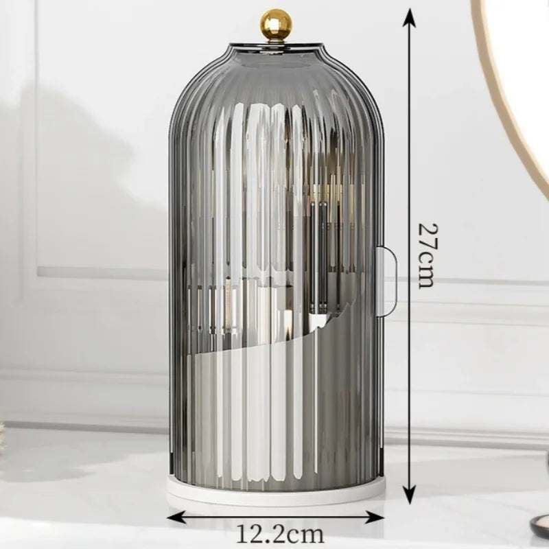 A tall, cylindrical glass brush holder with a dustproof lid and rotating makeup brushes on a white surface.