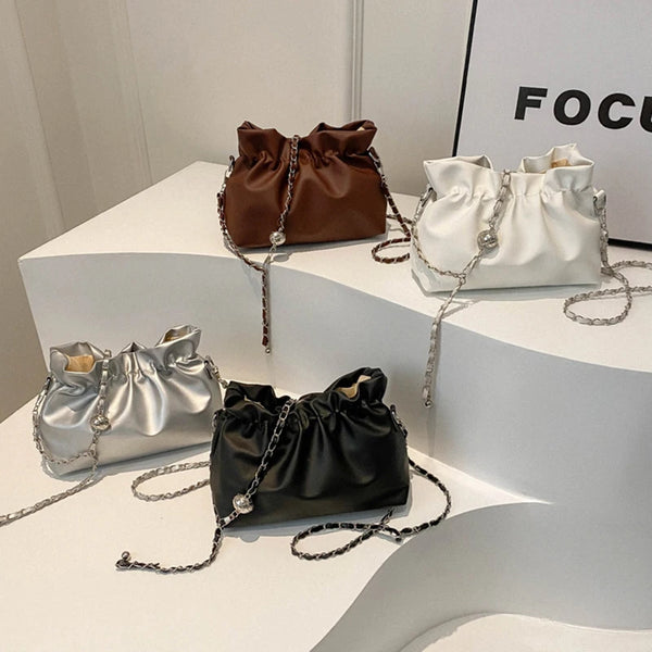 Vier klassische Ledertaschen in braun, weiß, silber und schwarz als Crossbody-Taschen.