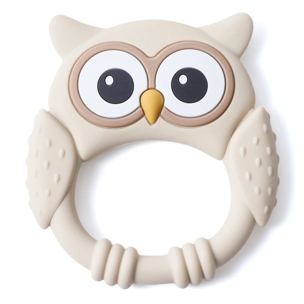 A beige silicone owl-shaped teether and rattle for babies with large eyes and textured body.