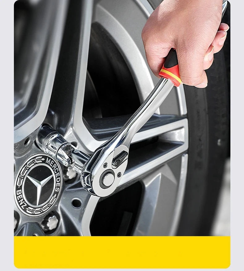 A hand is using a chrome-vanadium steel socket set and drive ratchet on a car wheel.
