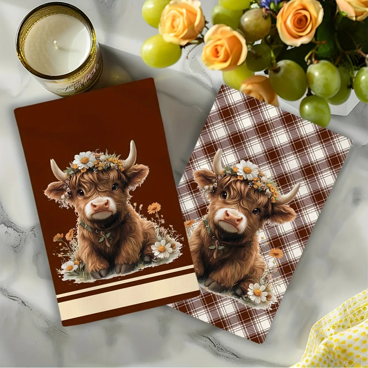 Two adorable Highland cows with floral wreaths are featured on plaid kitchen towels.