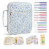 A light blue floral quilted Bible cover with a zipper pocket and carry handle, shown alongside various colored pens and a col