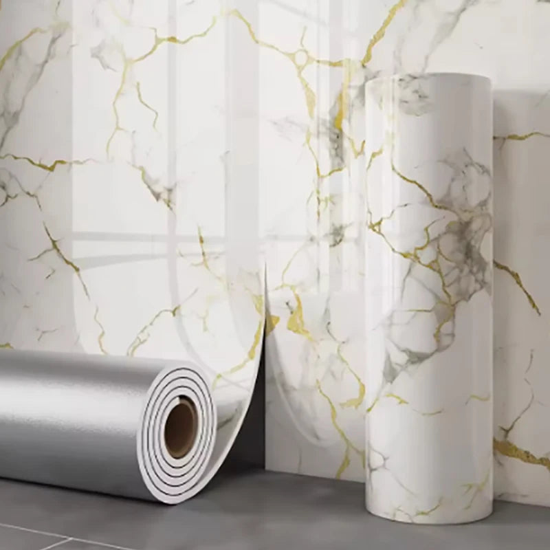 Roll of self-adhesive marble wallpaper featuring white and gold veining against a light gray background.