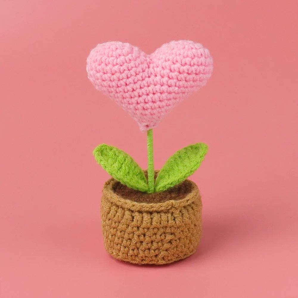 Handcrafted crochet heart flower in a woven pot with green leaves