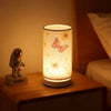 A Nordic retro USB table lamp with a fabric shade emitting a warm glow on a wooden surface.