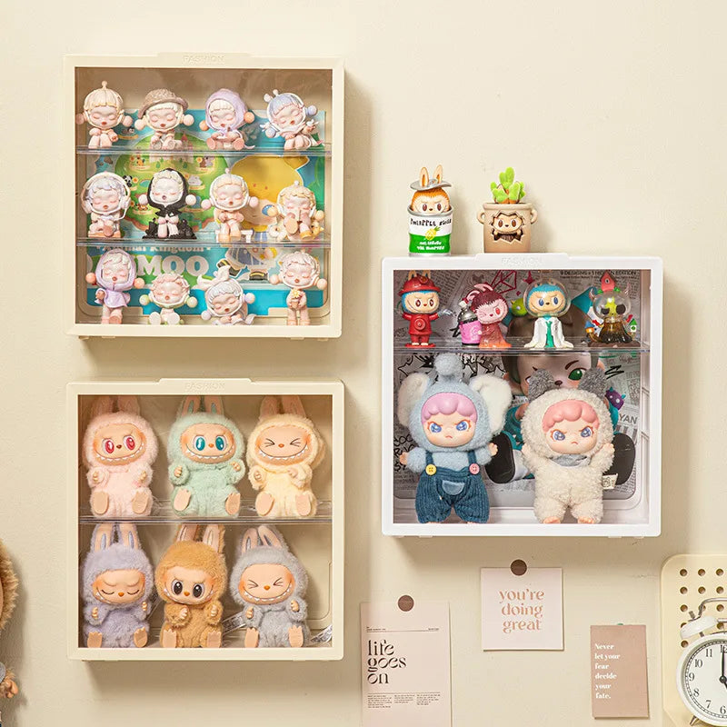A wall-mounted display case featuring various collectible dolls and figurines in clear plastic compartments.