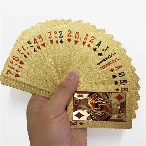 A hand holds a fan of 24K gold waterproof playing cards.