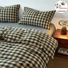 A plaid duvet cover in olive green and beige tones is displayed on a bed with matching pillows.