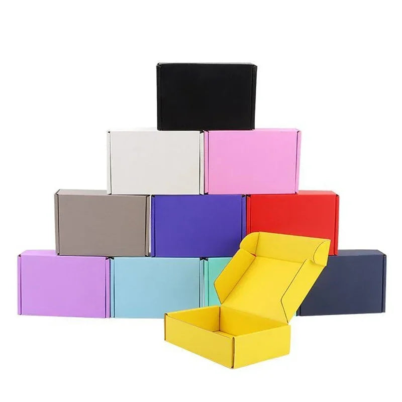 Eine Stapel farbenfroher Wellkartons in verschiedenen Farben wie Schwarz, Weiß, Pink, Lila, Rot und Gelb.