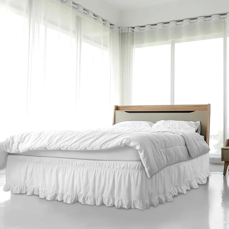 A white ruffled elastic bed skirt is shown beneath a bed in a bright, modern bedroom.