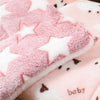 A close-up of a pink and white faux fur pet sleeping mat with star patterns.