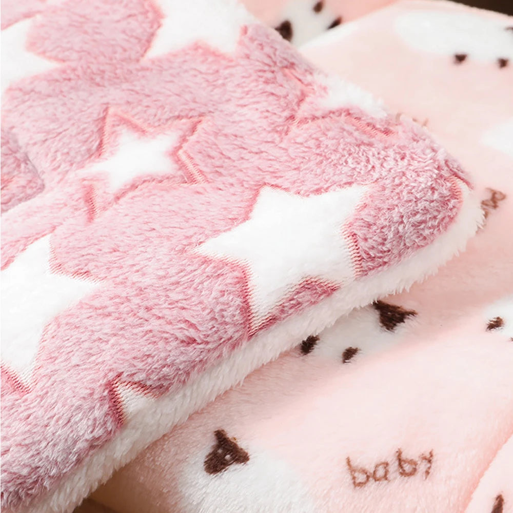 A close-up of a pink and white faux fur pet sleeping mat with star patterns.