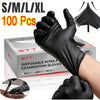 A hand wearing a black disposable nitrile examination glove is shown gripping a surface, with a box of 100 gloves in the back