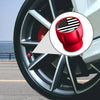 Close-up view of a red tire valve cap with an American flag design inserted into a silver wheel rim.