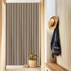 A close-up of a vertical wood slat wall panel installation next to a wooden shelf and a hanging dark blue jacket.