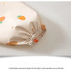 A round neck feeding bib in beige fabric with orange accents, shown lying flat.