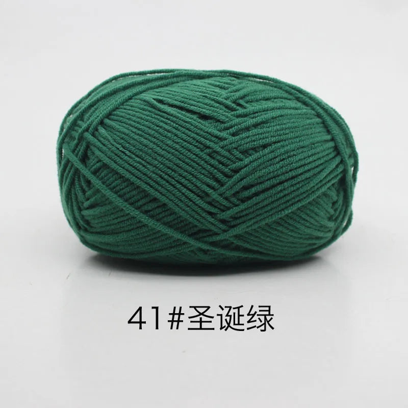 A ball of dark green 4-ply milk cotton yarn for knitting and crochet.