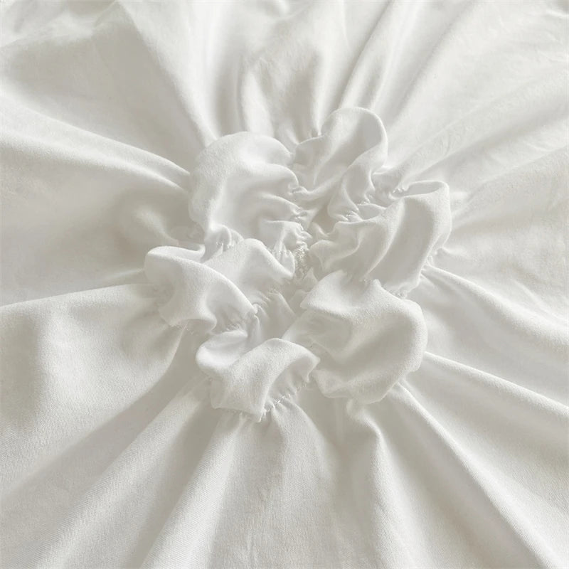 Close-up of a white duvet cover featuring a three-dimensional floral pinch-pleated design.