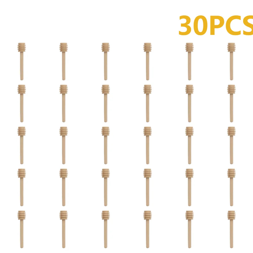 30 pieces of natural wood honey dipper sticks arranged in rows.