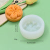 A white silicone mold shaped like a rose peony flower is shown next to a yellow silicone mold on a green background.
