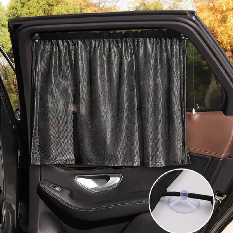 Black universal car side window sunshade with suction cups installed in a vehicle interior.