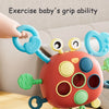A silicone pull string sensory toy for babies with colorful grips and rings being held by a hand.