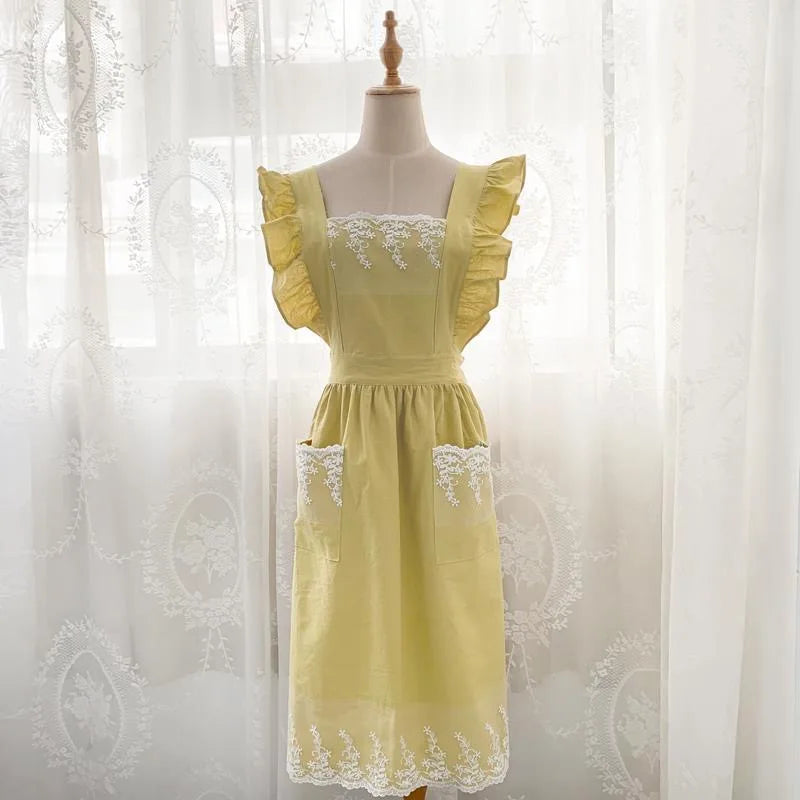 A yellow ruffled cotton linen kitchen apron with lace trim displayed on a mannequin.