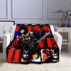 A black and orange flannel throw blanket featuring various images of the Kiss band members.