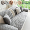Gray anti-slip sofa cover featuring a quilted geometric pattern with decorative fabric swatches.