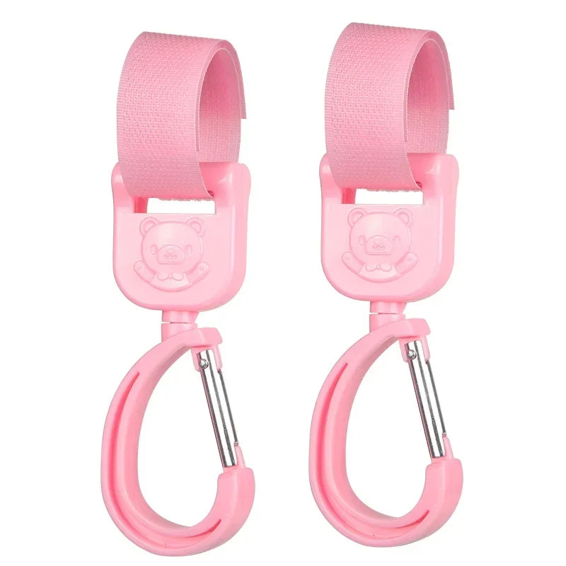 A pair of pink 360° rotating stroller hooks for hanging bags and essentials.