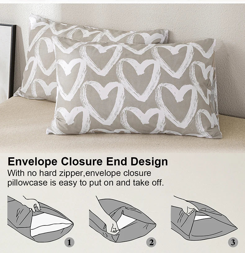 A close-up of a gray pillowcase with a white heart print, demonstrating the envelope closure end design.