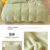 A close-up of soft, light green velvet bedding set featuring a duvet cover and pillowcases.