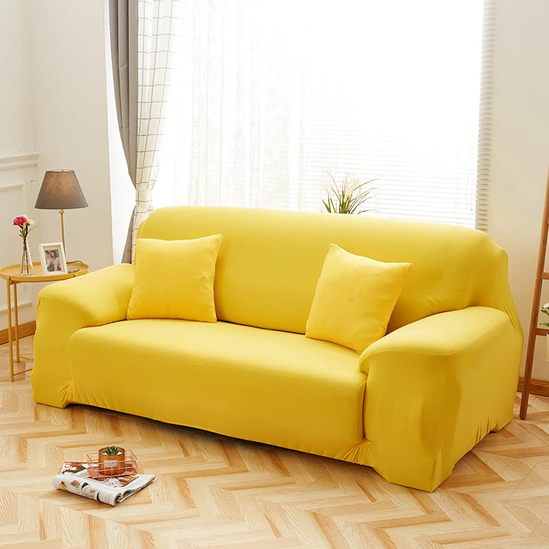 A bright yellow silky soft stretchable sofa cover for pet owners displayed on a light wood floor.