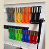 A row of magnetic wall-mounted spray can organizers in various colors including gray, yellow, orange, and black.