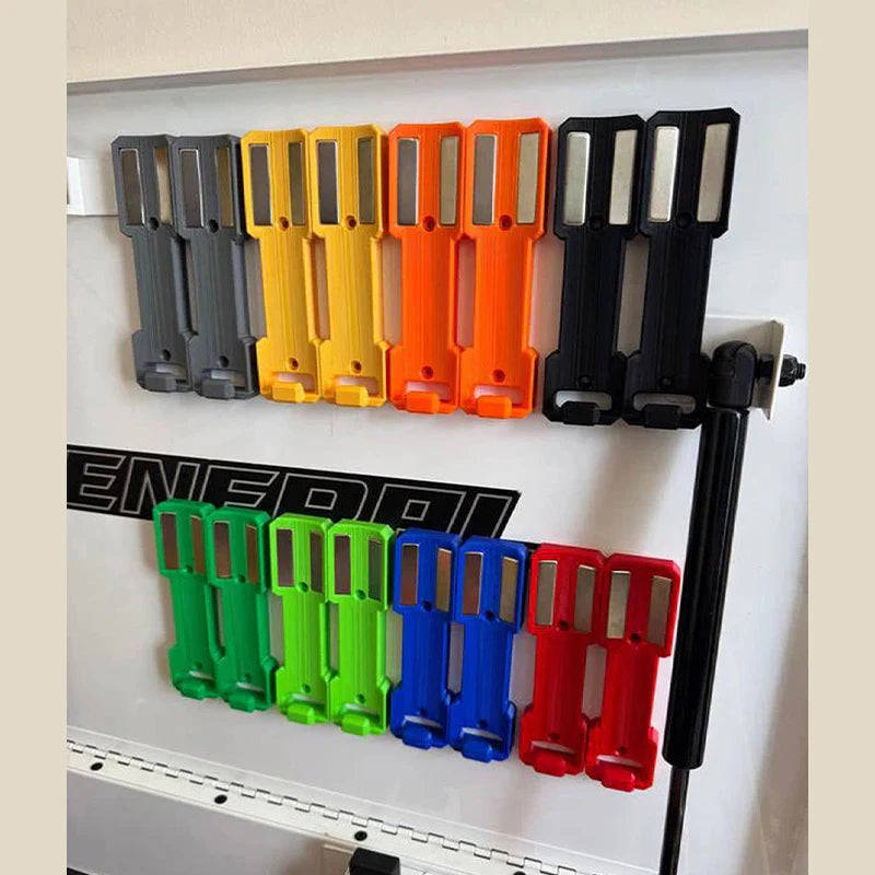 A row of magnetic wall-mounted spray can organizers in various colors including gray, yellow, orange, and black.