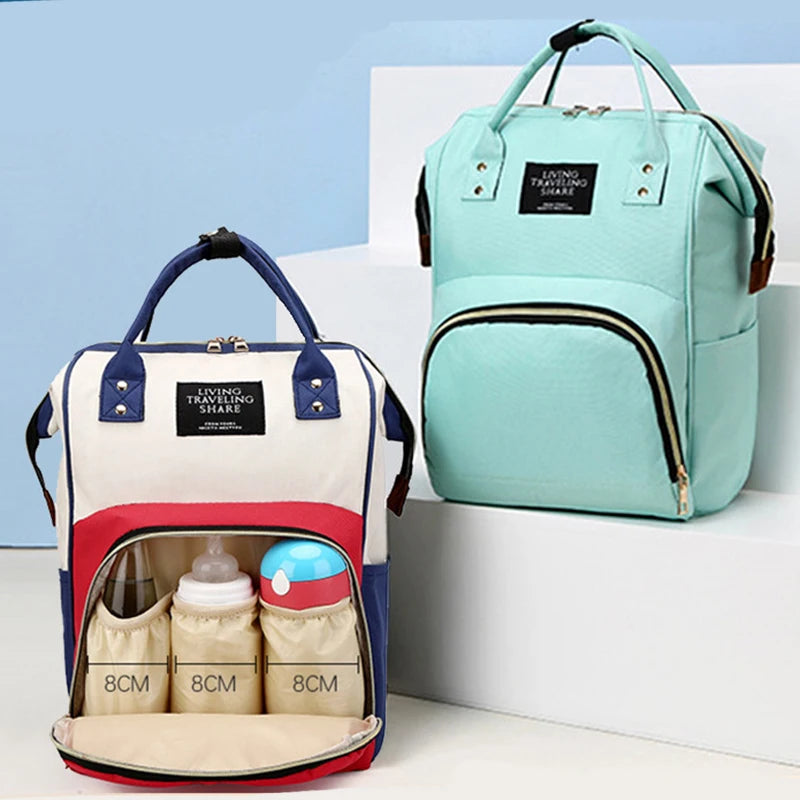Light teal insulated canvas diaper bag with a hanging hook and multiple compartments
