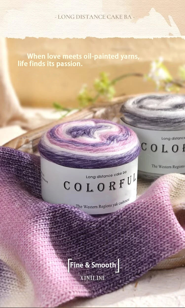 A purple and white yarn skein labeled Colorful Long distance cake BA is displayed on a wooden surface with soft lighting.
