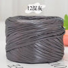 A spool of metallic gray flat ribbon yarn for crochet and knitting