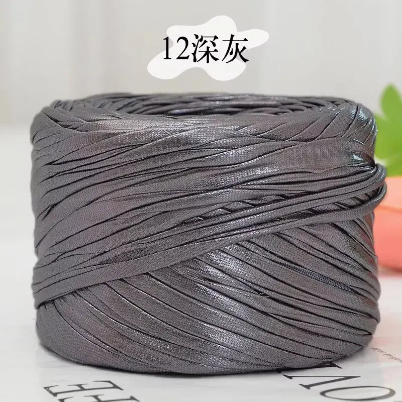 A spool of metallic gray flat ribbon yarn for crochet and knitting