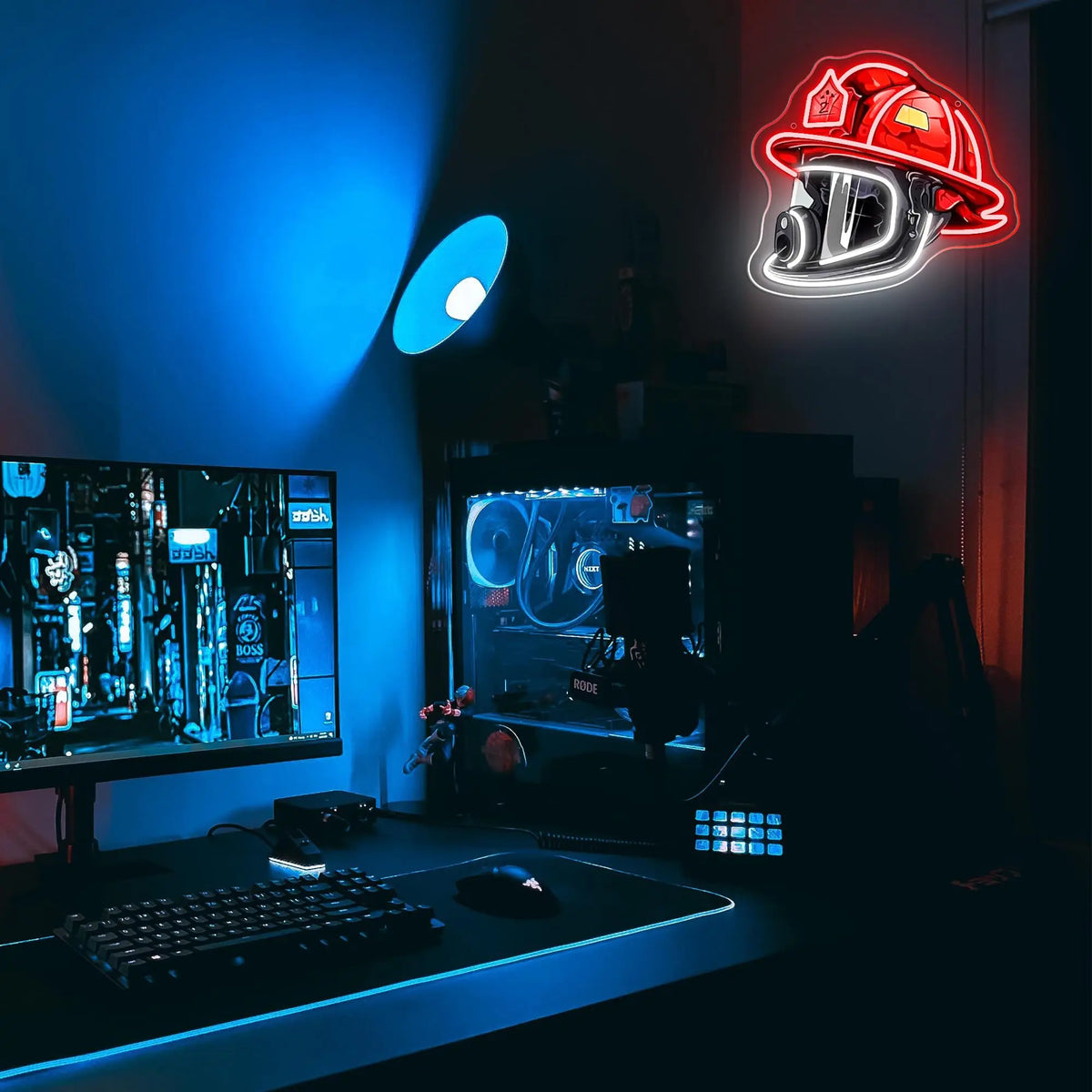 A gaming setup featuring a firefighter helmet neon sign and a computer monitor with a dark theme.